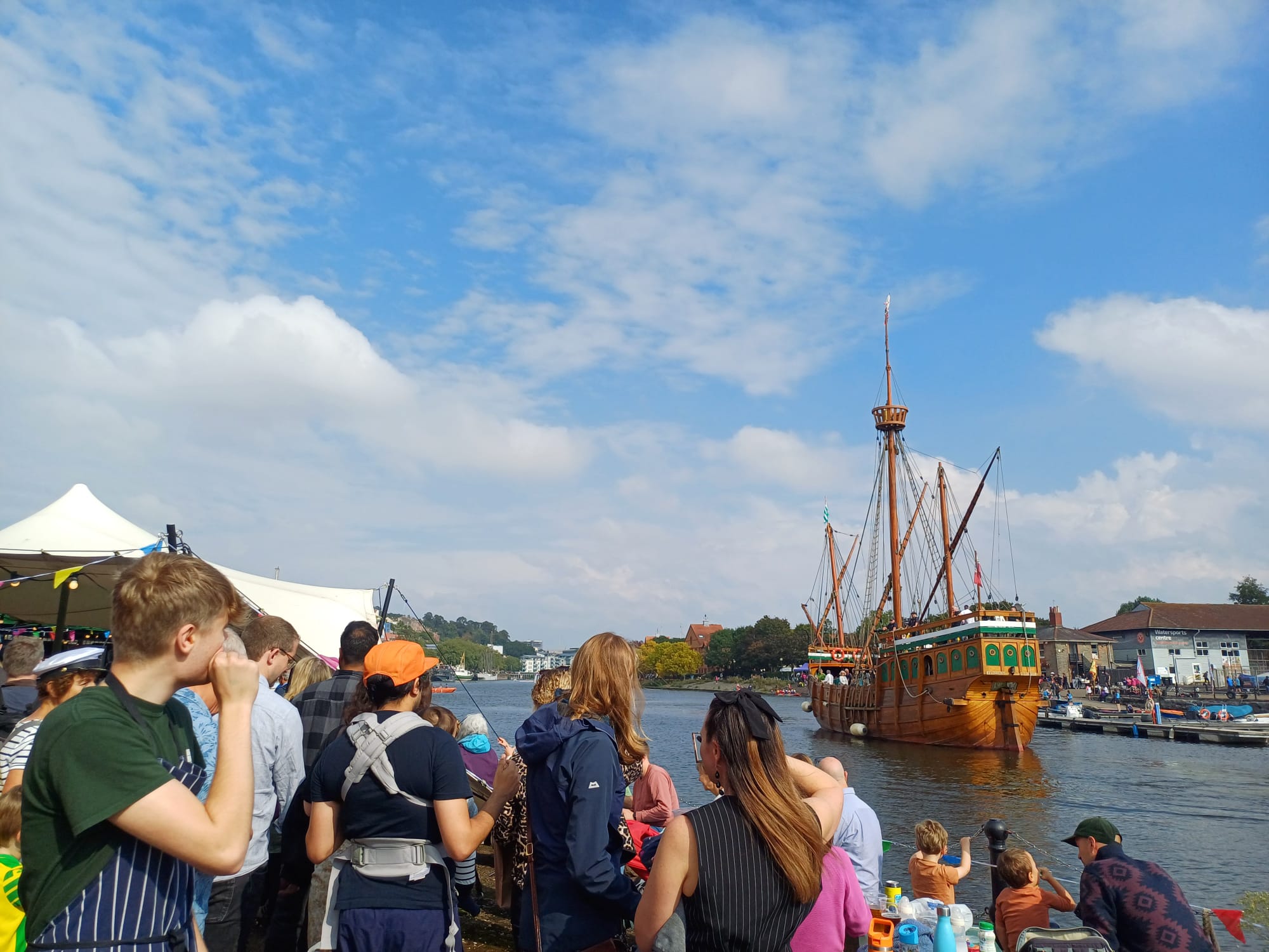 A group of people looking out onto a big ship in the harbour from Underfall Yard