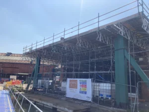 Construction site on a boatbuilding workshop. The overhang roof covers a walkway through the boatyard.